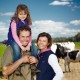 A family standing in front of cows