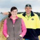 A man and woman standing in front of bale of hay