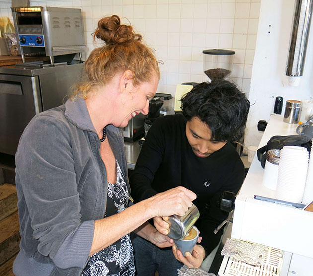 Woman leaning to pour steamed milk