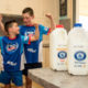 Two boys smiling and flexing muscles behind Riverina Fresh milk